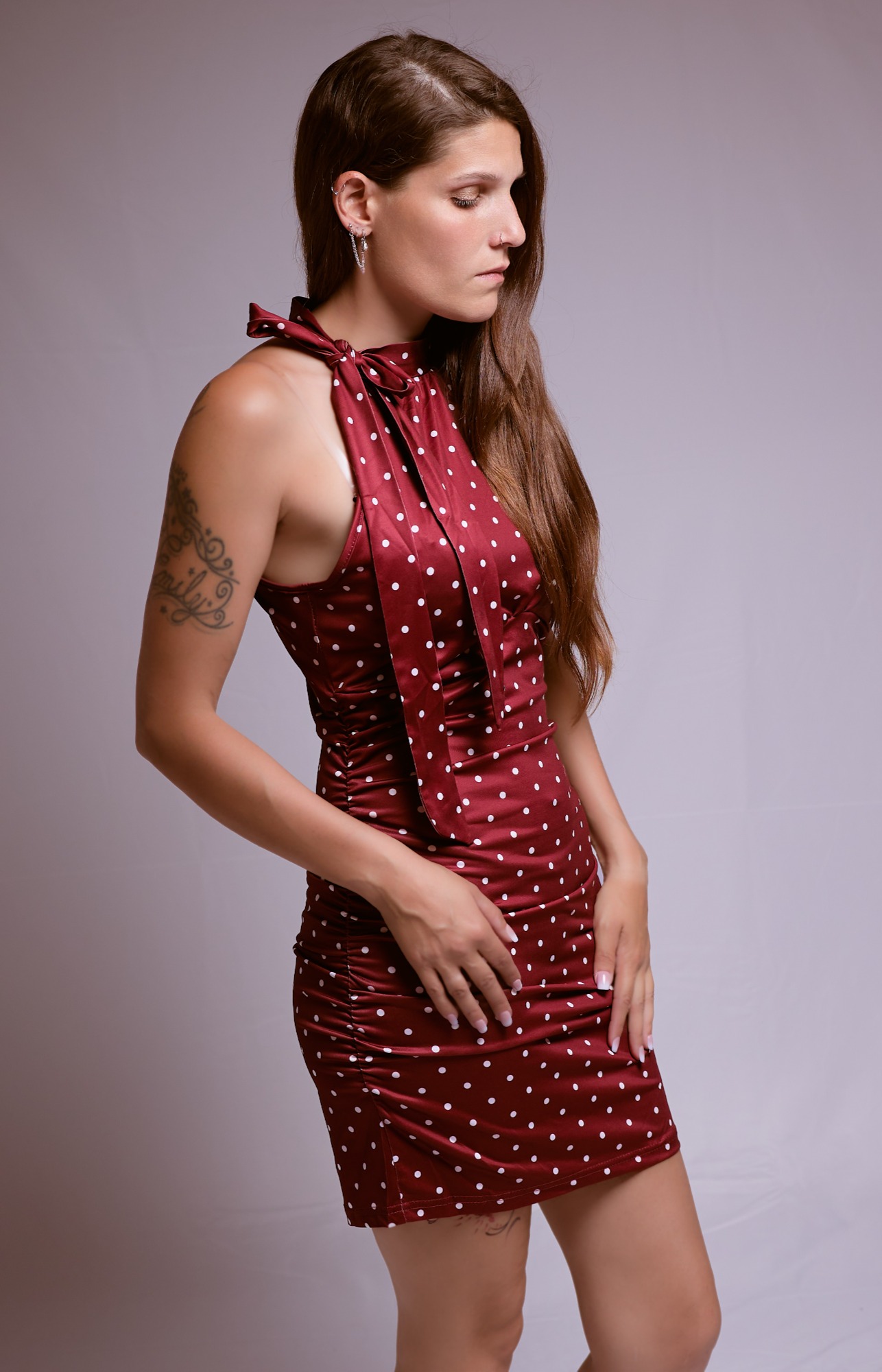 Eine Frau in einem roten, gepunkteten Kleid mit schleifenartigem Kragen.